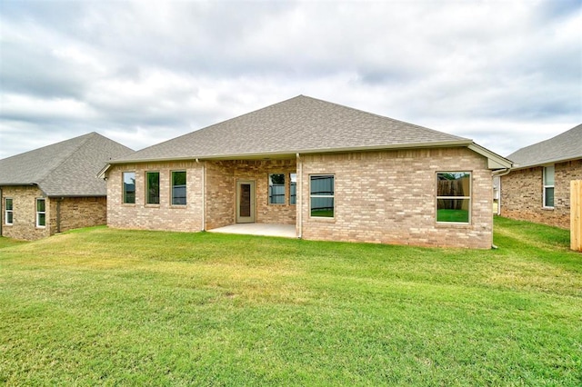 rear view of property with a lawn and a patio