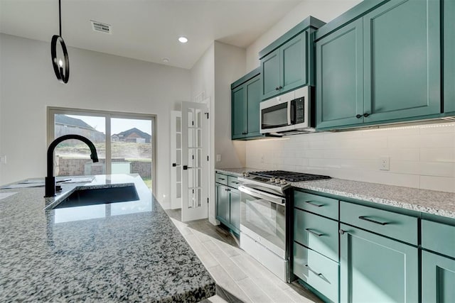 kitchen with light stone countertops, sink, stainless steel appliances, light hardwood / wood-style flooring, and green cabinetry