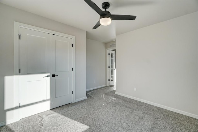 unfurnished bedroom with ceiling fan, light carpet, and a closet