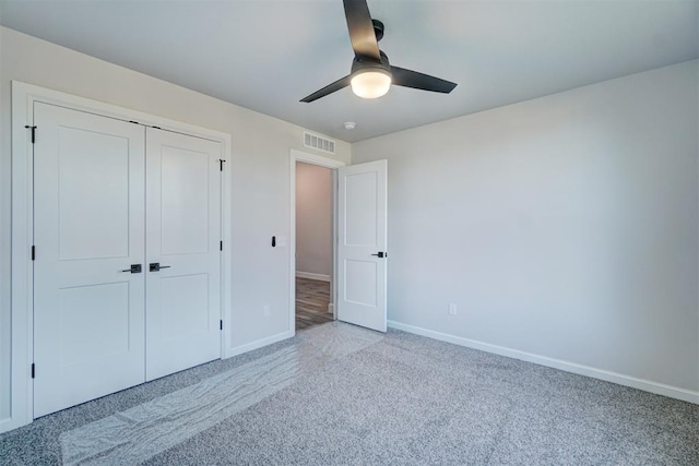 unfurnished bedroom with ceiling fan, a closet, and light carpet