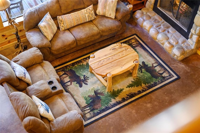 carpeted living room featuring a stone fireplace