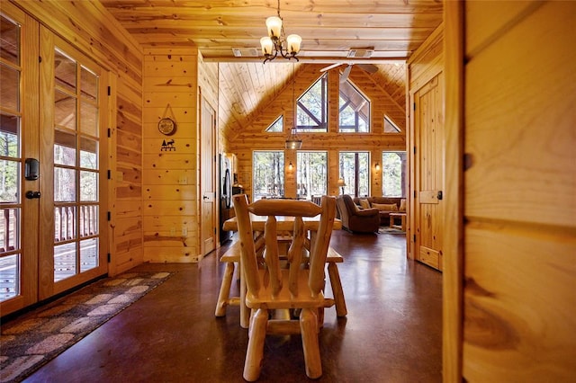 dining space featuring wood walls, plenty of natural light, wooden ceiling, and an inviting chandelier