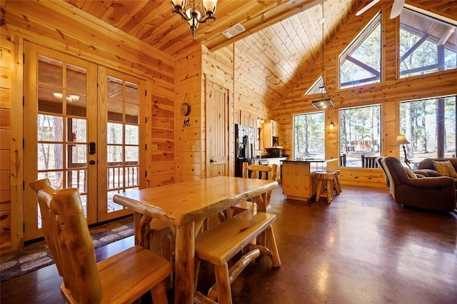 dining area with french doors, visible vents, wooden walls, concrete flooring, and wooden ceiling