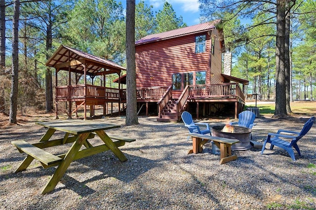 view of playground featuring stairs, a fire pit, and a wooden deck