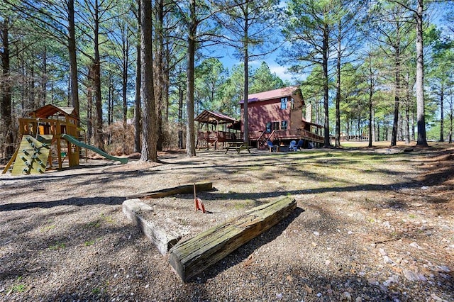 view of yard with playground community and a deck