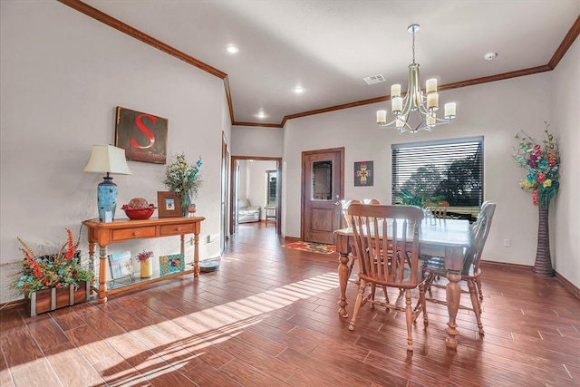 dining room featuring crown molding, plenty of natural light, a notable chandelier, and hardwood / wood-style flooring