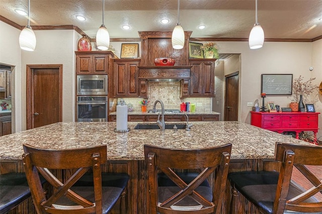 11335 N 1930th Rd, Sayre, OK 73662 - kitchen with stainless steel appliances, a sink, ornamental molding, tasteful backsplash, and hanging light fixtures