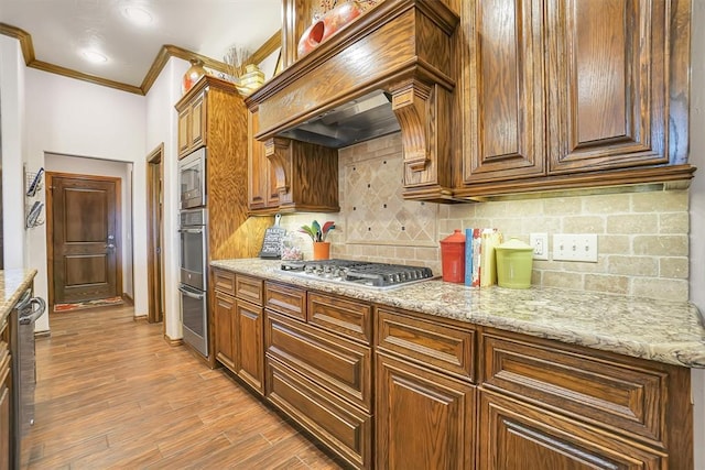 11335 N 1930th Rd, Sayre, OK 73662 - kitchen featuring appliances with stainless steel finishes, crown molding, backsplash, light wood-type flooring, and light stone counters