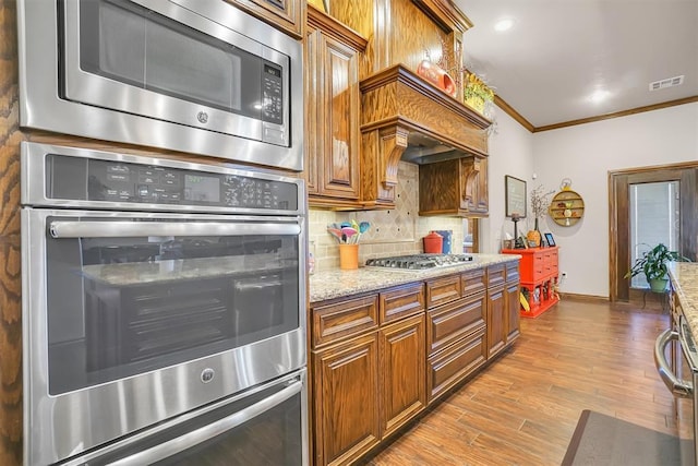 11335 N 1930th Rd, Sayre, OK 73662 - kitchen with appliances with stainless steel finishes, crown molding, baseboards, decorative backsplash, and light stone countertops
