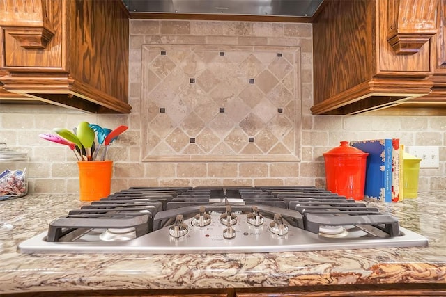 11335 N 1930th Rd, Sayre, OK 73662 - kitchen view of stainless steel gas stovetop, tasteful backsplash, and brown cabinets