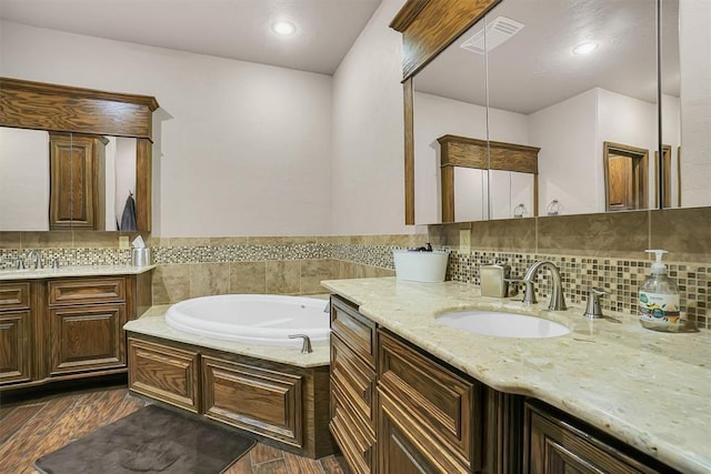 11335 N 1930th Rd, Sayre, OK 73662 - bathroom with two vanities, a bath, wood finished floors, backsplash, and recessed lighting