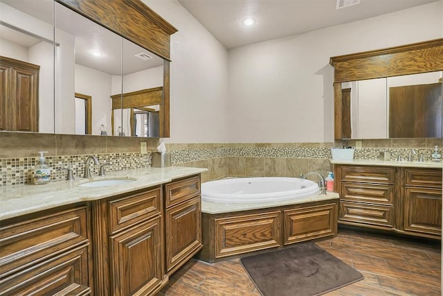 bathroom featuring a bathing tub, decorative backsplash, hardwood / wood-style floors, and vanity