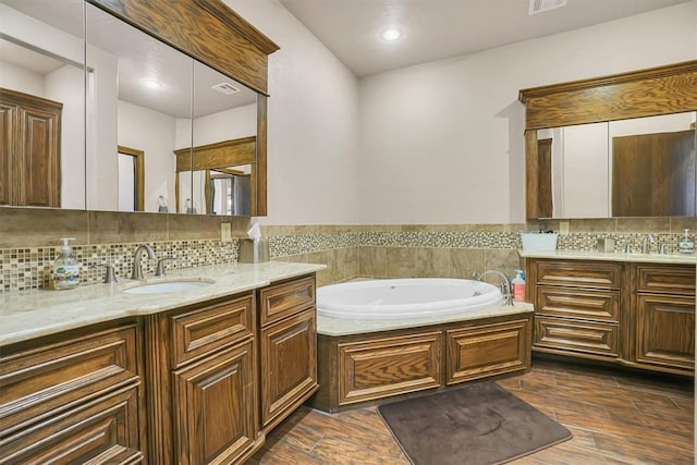 11335 N 1930th Rd, Sayre, OK 73662 - full bath with two vanities, a garden tub, decorative backsplash, wood finished floors, and recessed lighting