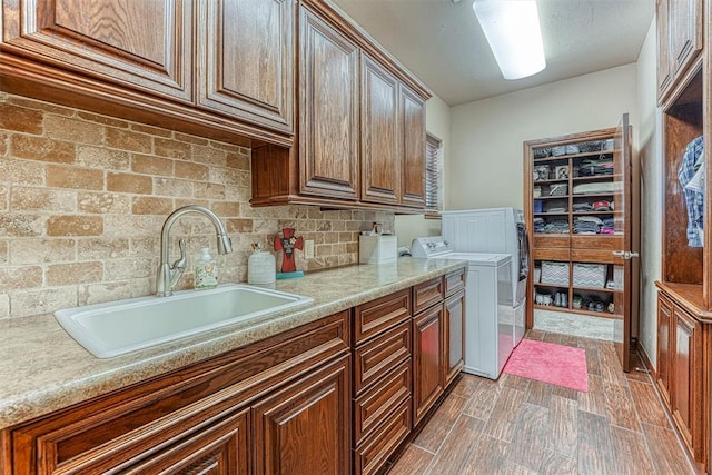 washroom with cabinets, washing machine and dryer, dark wood-type flooring, and sink