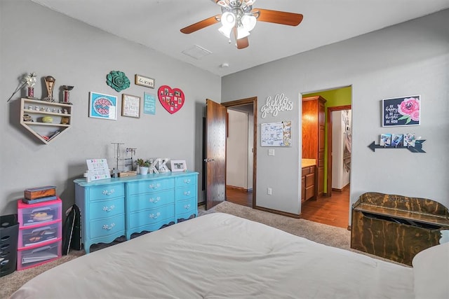 carpeted bedroom with ceiling fan and connected bathroom