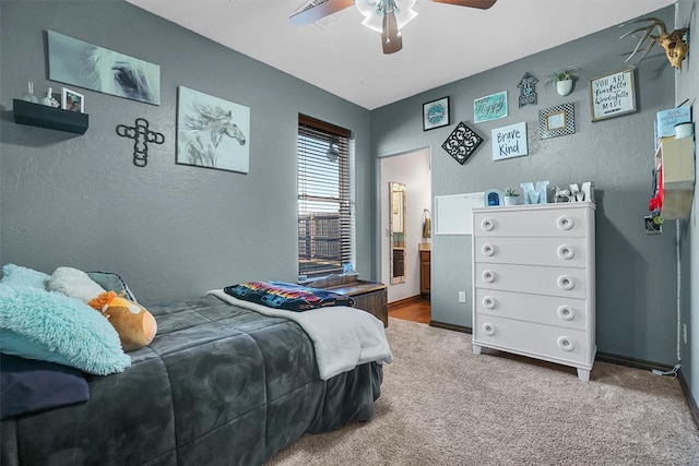 carpeted bedroom featuring ensuite bath and ceiling fan