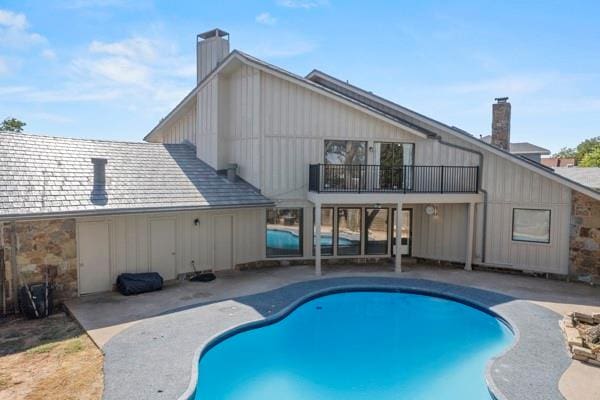 back of property featuring a balcony and a patio area