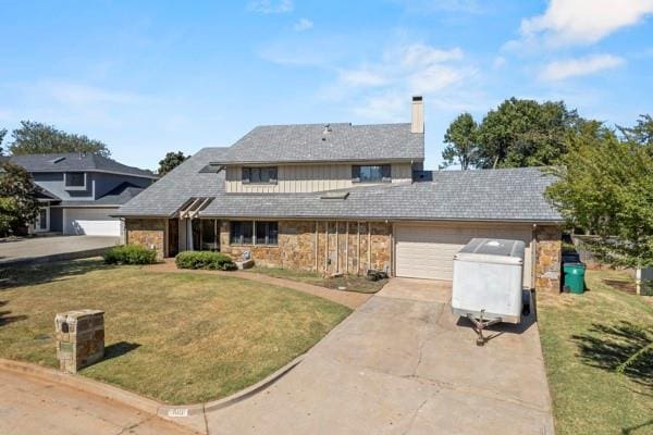 view of property featuring a garage and a front lawn