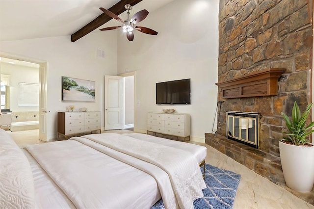 bedroom featuring ceiling fan, ensuite bath, a fireplace, and vaulted ceiling with beams