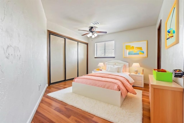 bedroom featuring ceiling fan, a closet, and light hardwood / wood-style flooring