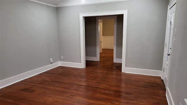 spare room with dark hardwood / wood-style flooring and ornamental molding