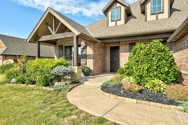 view of exterior entry with a lawn