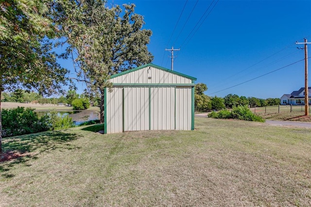 view of outbuilding with a water view and a lawn