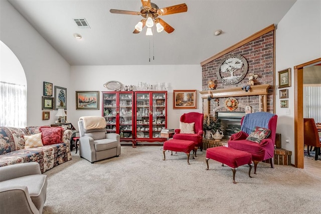 carpeted living room with ceiling fan, vaulted ceiling, and a brick fireplace