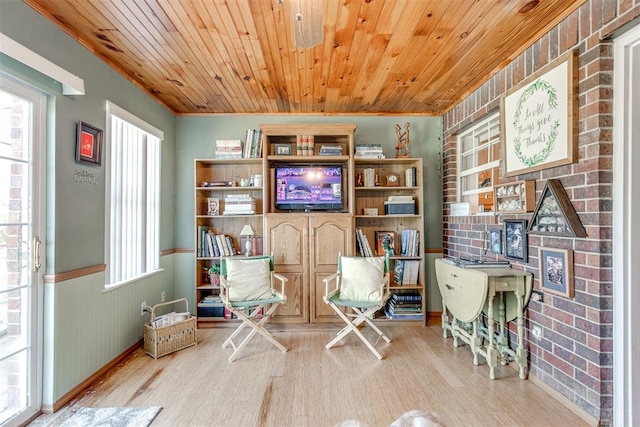 living area with light wood-type flooring, wooden ceiling, and brick wall