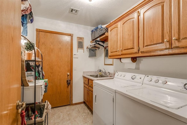 washroom featuring cabinets, a textured ceiling, separate washer and dryer, and sink