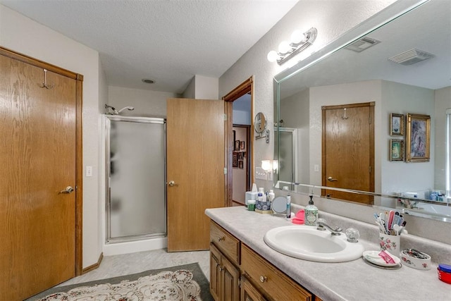 bathroom with vanity, a textured ceiling, and an enclosed shower