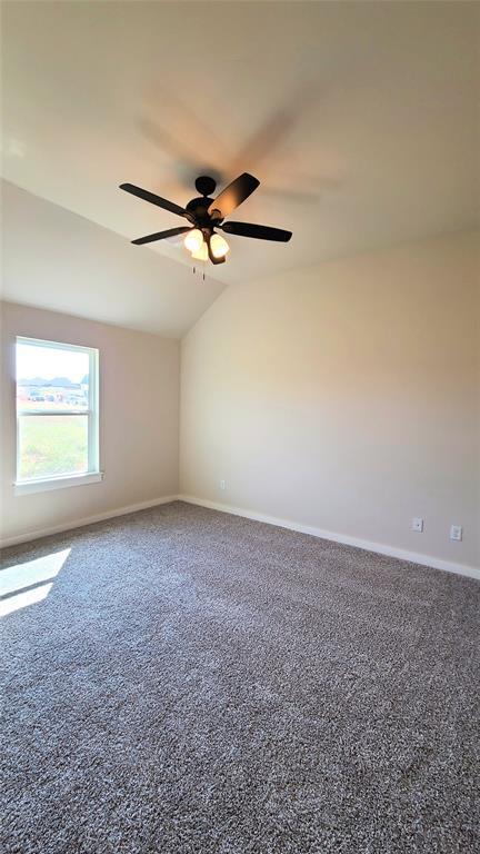9321 SW 35th St, Oklahoma City, OK 73179 - carpeted spare room featuring lofted ceiling, baseboards, and a ceiling fan