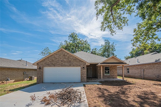 single story home featuring central air condition unit and a garage