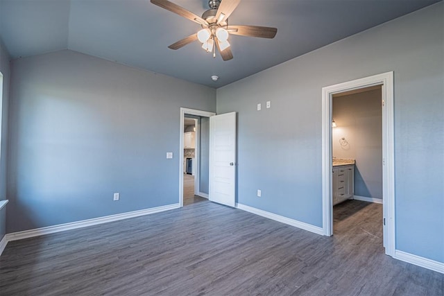 unfurnished bedroom with ceiling fan, lofted ceiling, dark wood-type flooring, and ensuite bath