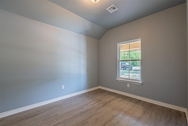 unfurnished room with wood-type flooring and vaulted ceiling