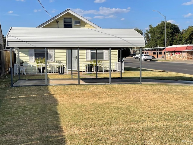 rear view of house with a carport and a yard