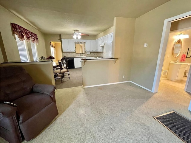 carpeted living room with ceiling fan and sink