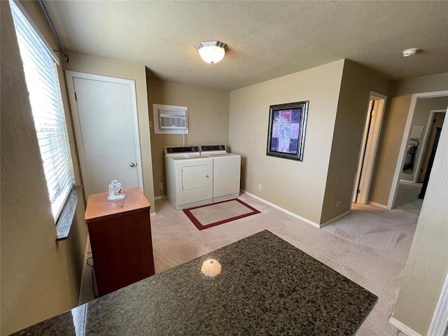 laundry room featuring a textured ceiling, separate washer and dryer, and light carpet