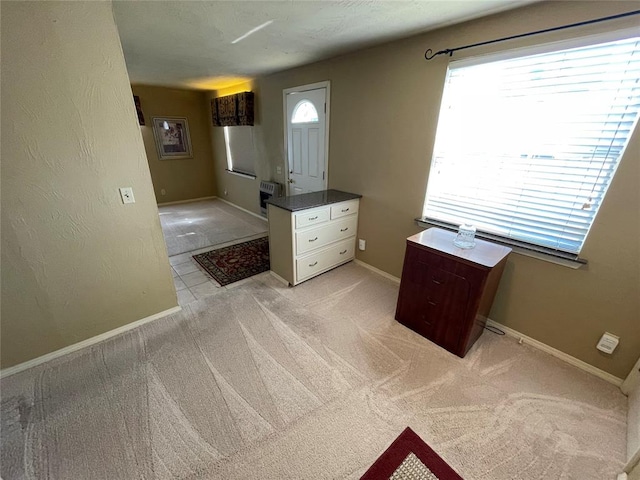 foyer with a wealth of natural light and light colored carpet