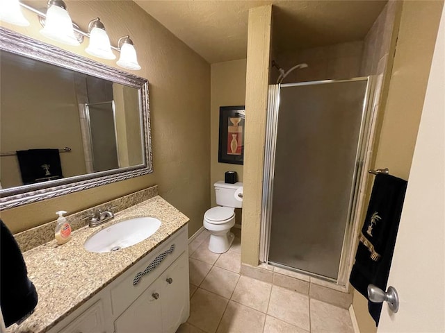 bathroom with tile patterned flooring, vanity, toilet, and walk in shower