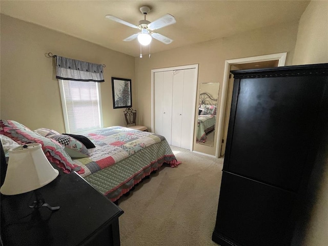 bedroom featuring a closet, light colored carpet, black fridge, and ceiling fan