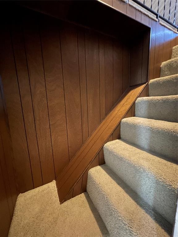 staircase featuring wood walls