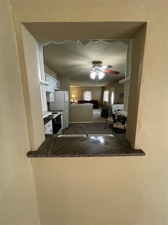 kitchen featuring kitchen peninsula, ceiling fan, and white refrigerator