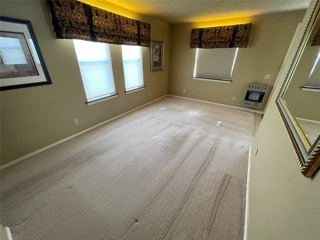 empty room featuring light carpet and heating unit