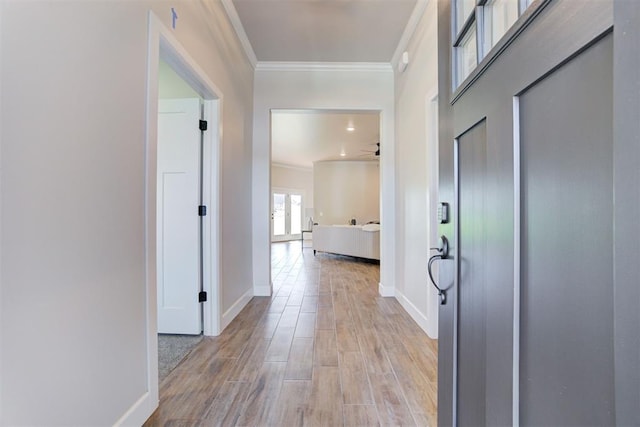 hall with light wood-type flooring and ornamental molding