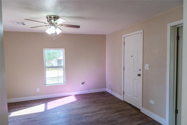 empty room with lofted ceiling, ceiling fan, dark hardwood / wood-style flooring, and a textured ceiling