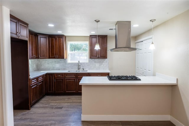 kitchen featuring gas cooktop, sink, decorative light fixtures, and range hood