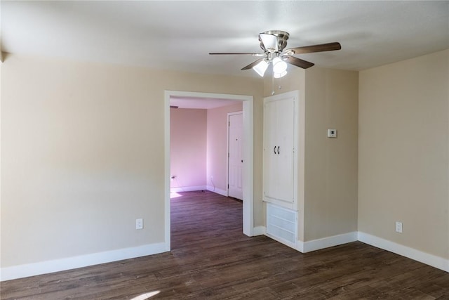 empty room with ceiling fan and dark wood-type flooring