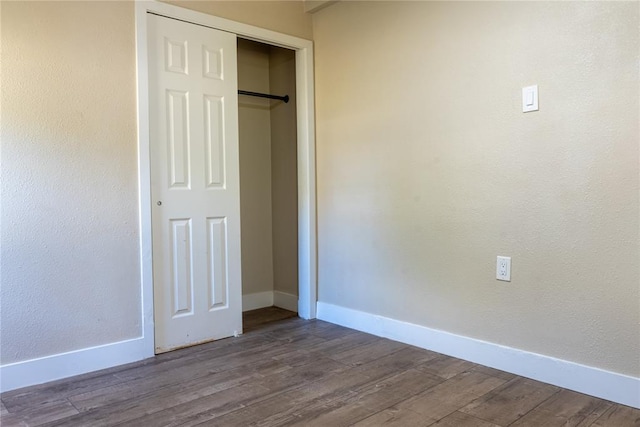 unfurnished bedroom with hardwood / wood-style flooring and a closet