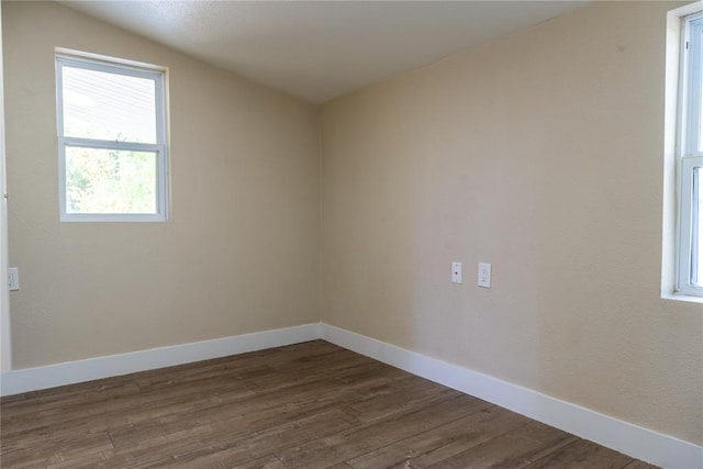 empty room featuring dark wood-type flooring and vaulted ceiling